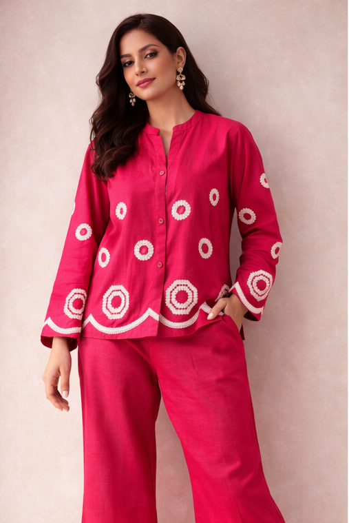 Woman wearing a pink outfit with white patterns on a beige background